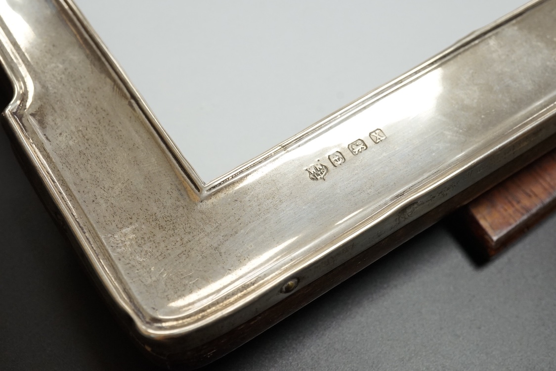 A pair of George V silver mounted shaped rectangular photograph frames, William Neale & Son Ltd, Birmingham, 1922 & 1925, 26.7cm.